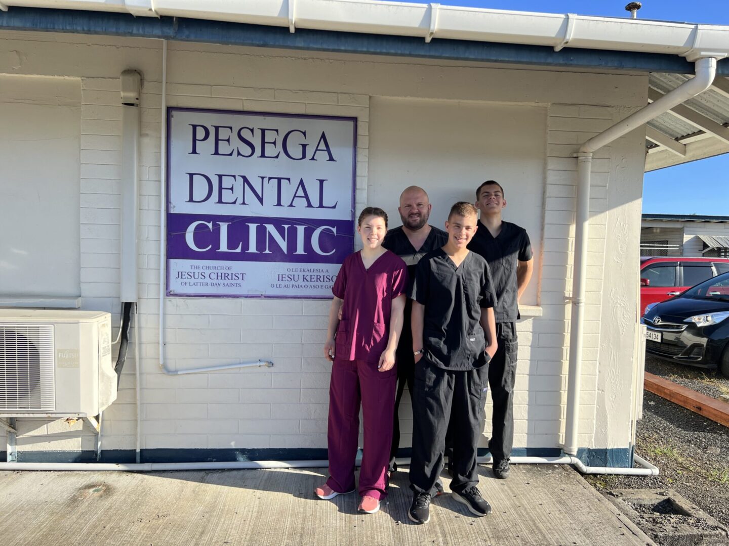 Team posing at dental clinic entrance