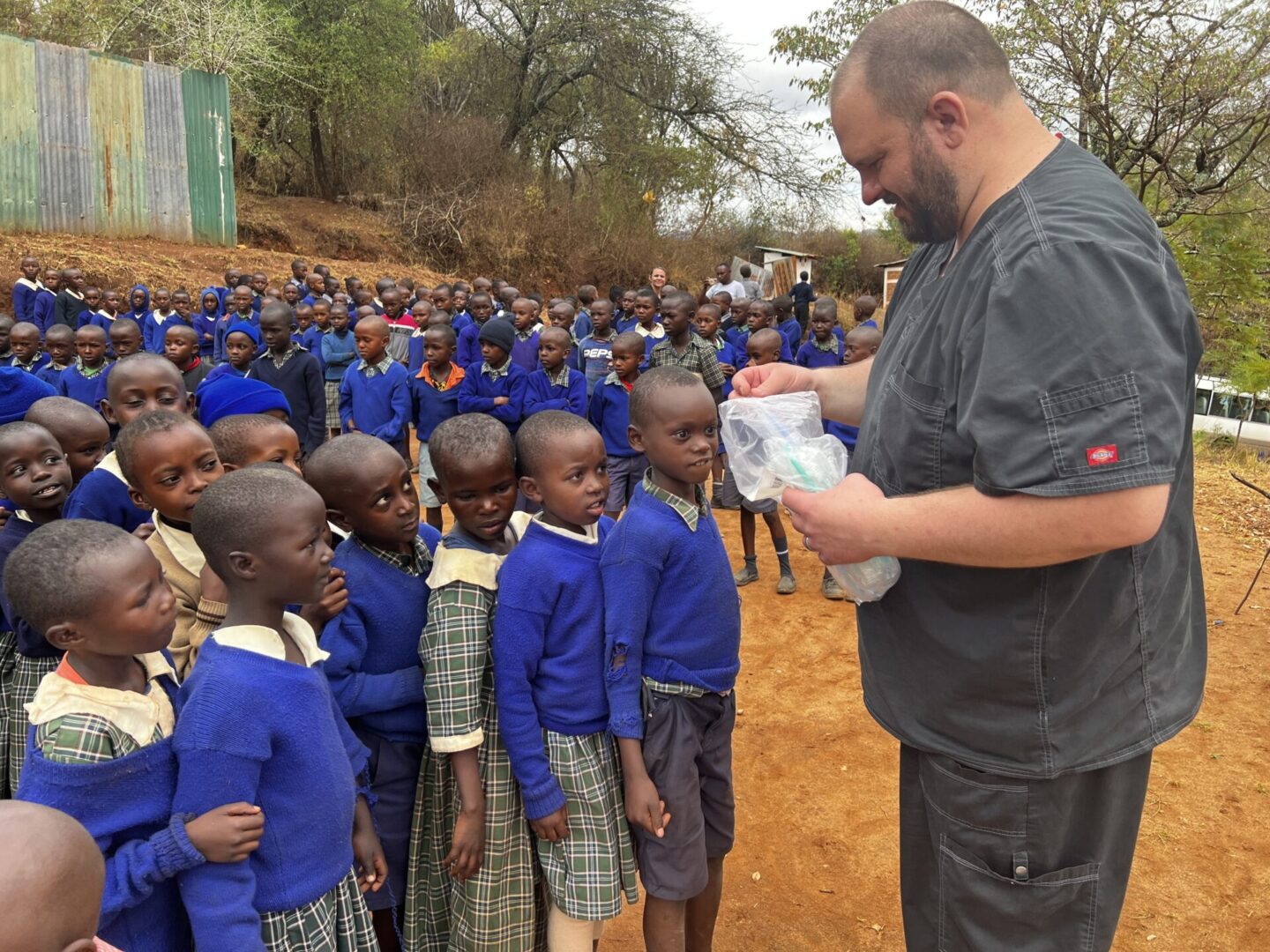 Man distributing supplies to schoolchildren