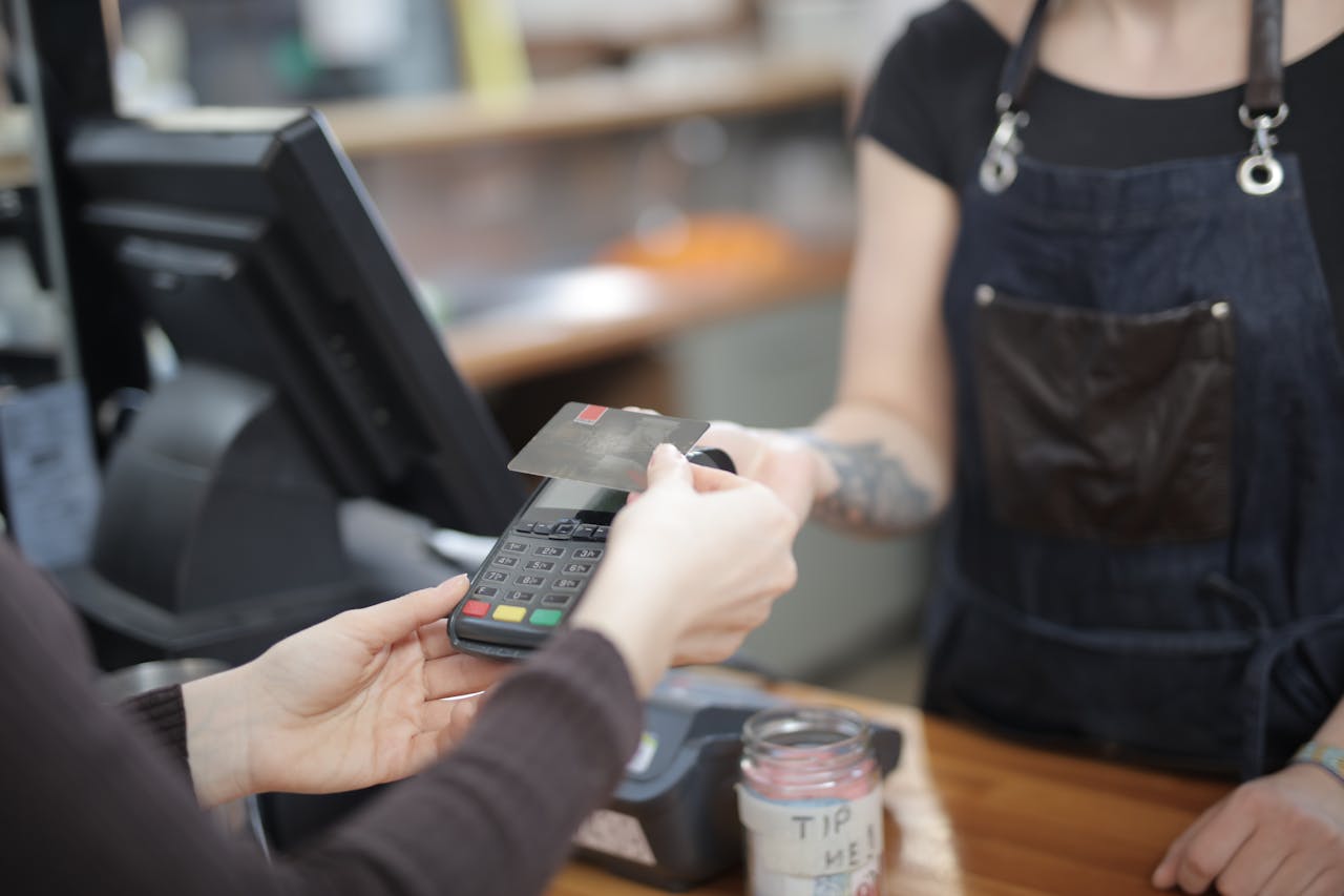 Customer paying with a contactless card at a cafe counter.